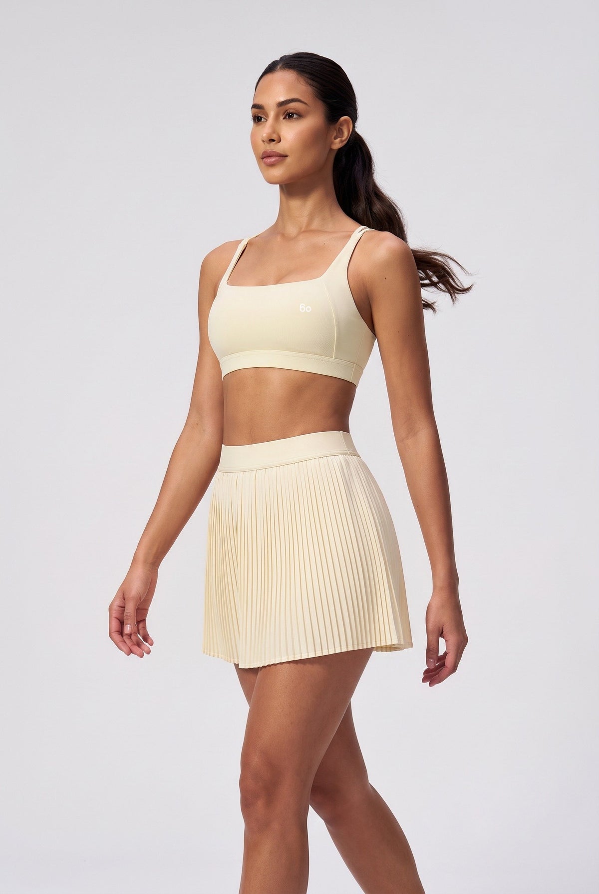 CORA bra top & pleated skirt set in Light Yellow – women's padel set by Six'o – full-length studio photo
