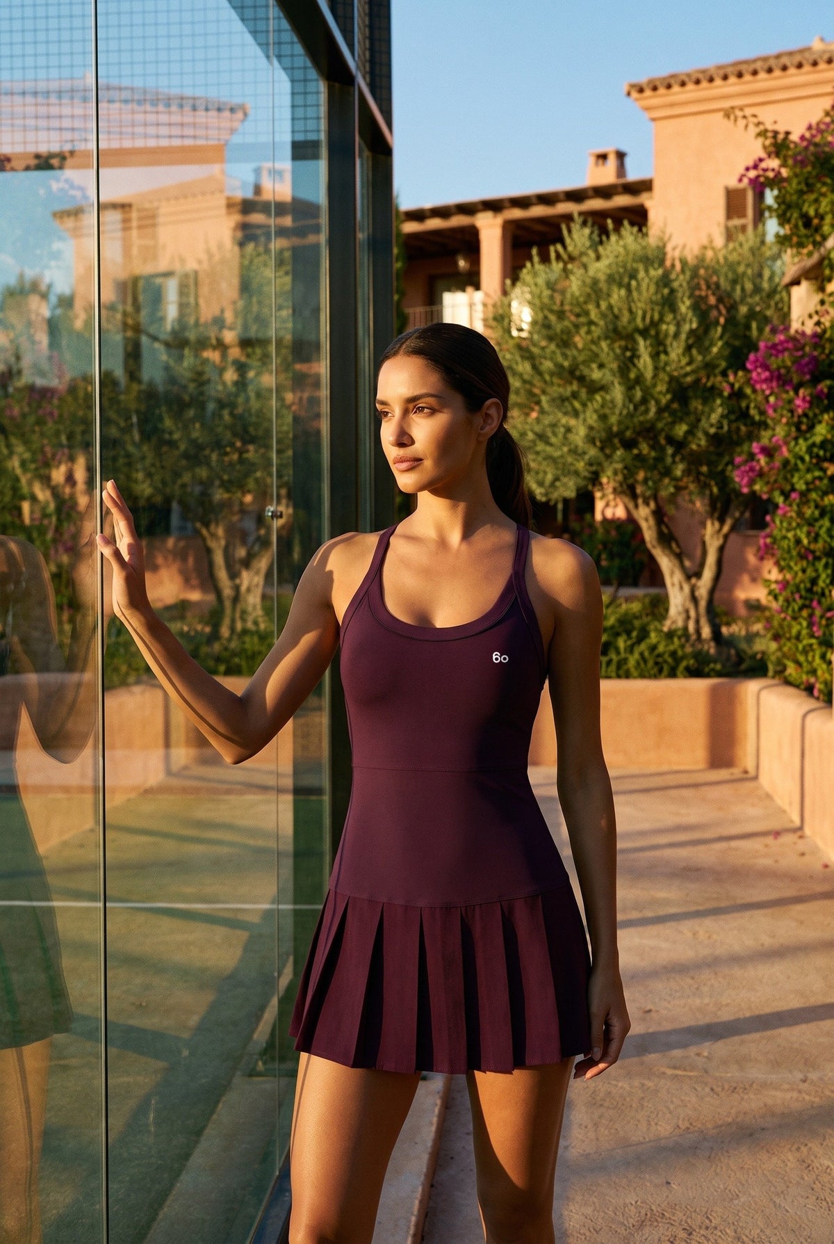 ELLA scoop neck pleated padel dress in Purple – women's padel dress by Six'o – lifestyle photo at the padel club