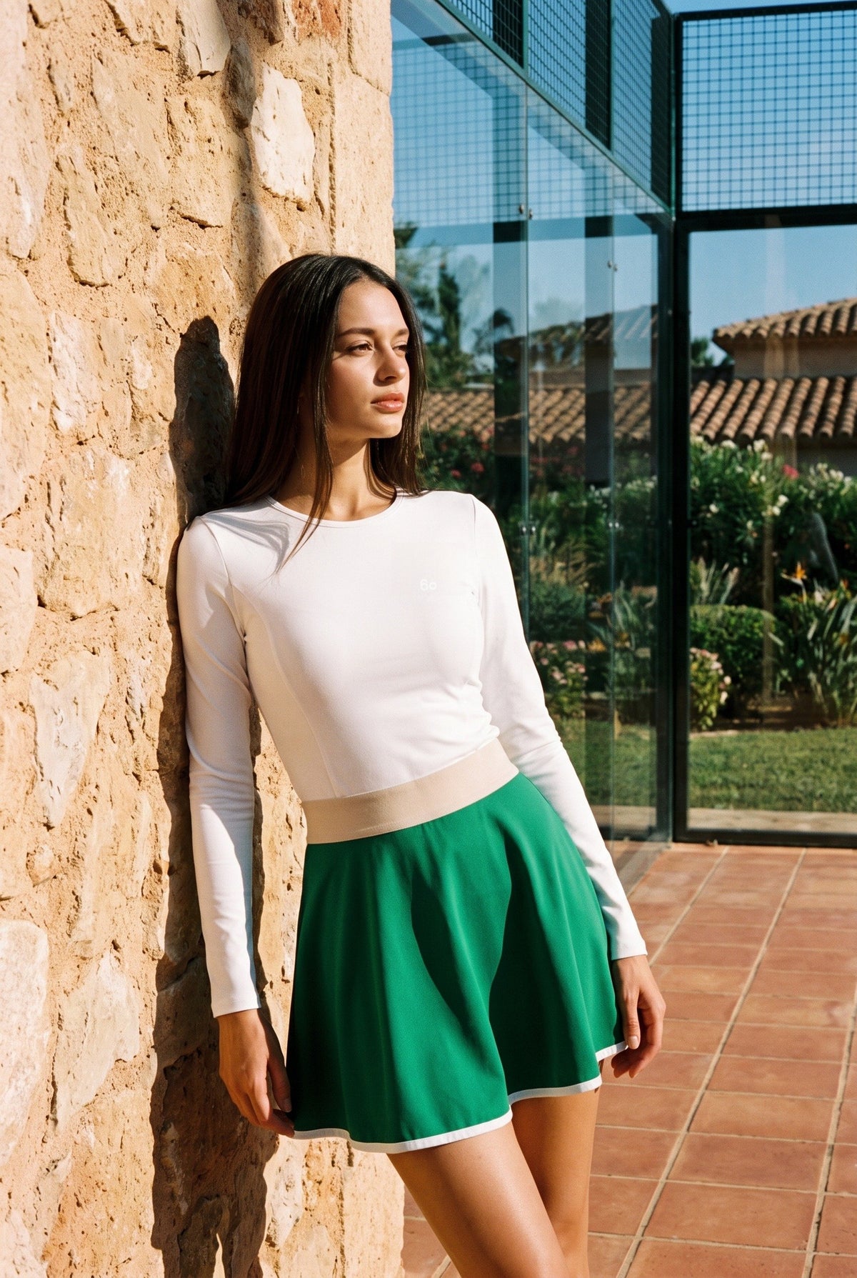 GRACE zip sweater & skirt set in White sweater green skirt – women's padel set by Six'o – lifestyle photo at the padel club