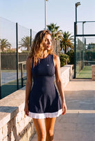 AMBER cross-back padel dress in Navy – women's padel dress by Six'o – lifestyle photo at the padel club