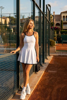 BELLA halter contrast trim dress in White – women's padel dress by Six'o – lifestyle photo at the padel club