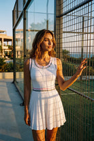 CHLOE varsity v-neck padel dress in Pink – women's padel dress by Six'o – lifestyle photo at the padel club