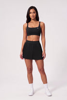 CORA bra top & pleated skirt set in Black – women's padel set by Six'o – front view