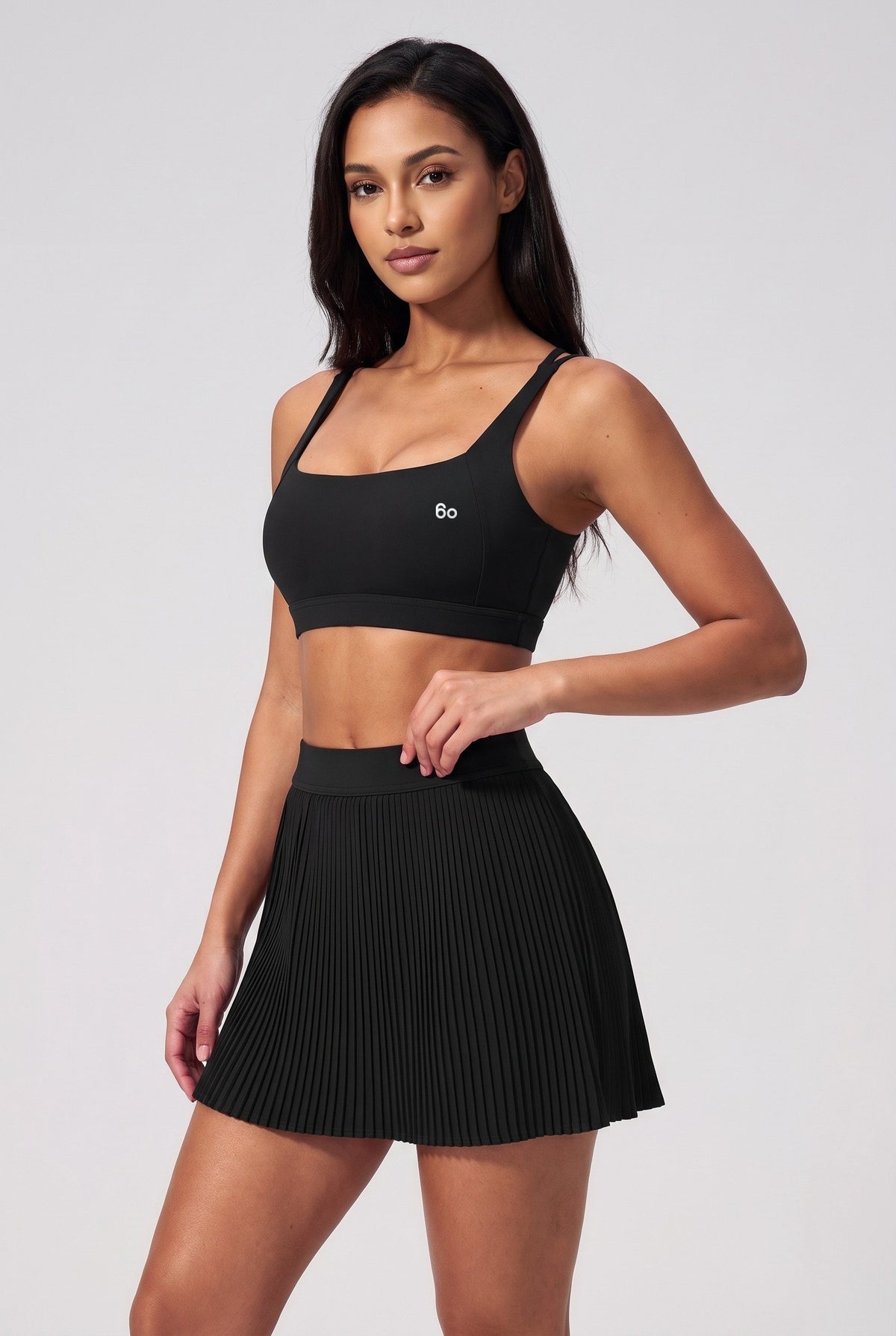 CORA bra top & pleated skirt set in Black – women's padel set by Six'o – studio photo