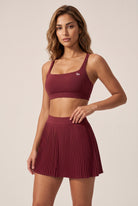 CORA bra top & pleated skirt set in Cherry red – women's padel set by Six'o – studio photo