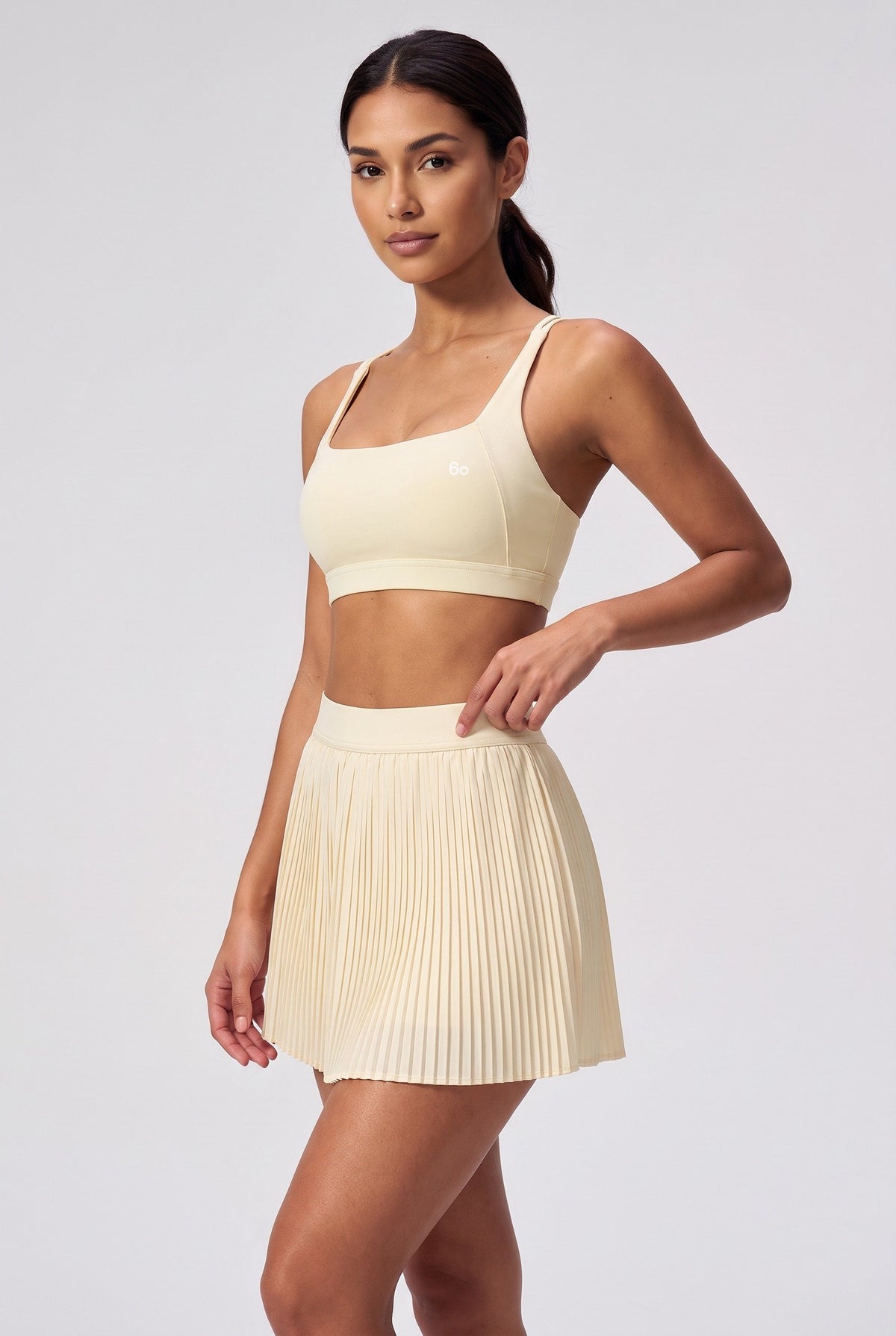 CORA bra top & pleated skirt set in Light Yellow – women's padel set by Six'o – studio photo