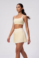 CORA bra top & pleated skirt set in Light Yellow – women's padel set by Six'o – full-length studio photo