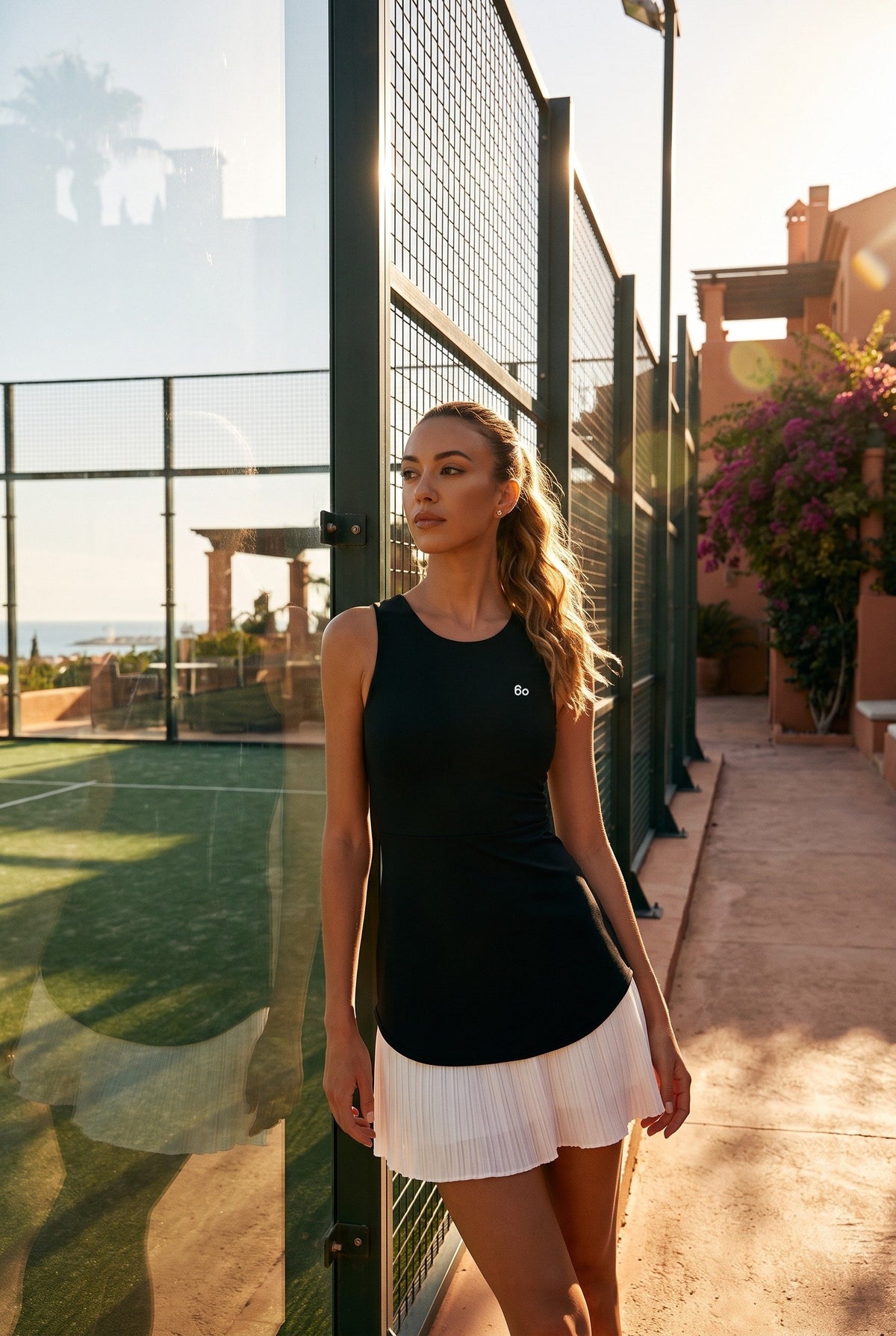 DAISY colourblock pleated dress in Black – women's padel dress by Six'o – lifestyle photo at the padel club