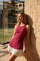 DAISY colourblock pleated dress in Persian red – women's padel dress by Six'o – lifestyle photo at the padel club