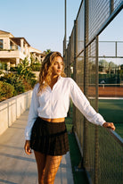 ELSA cropped jacket & pleated skirt set in White jacket black skirt – women's padel set by Six'o – lifestyle photo