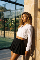 ELSA cropped jacket & pleated skirt set in White jacket black skirt – women's padel set by Six'o – lifestyle photo