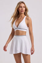 FREYA plunge bra & skirt set in White – women's padel set by Six'o – full-length studio photo