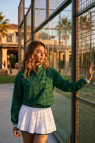 GRACE zip sweater & skirt set in Green sweater white skirt – women's padel set by Six'o – lifestyle photo at the padel club