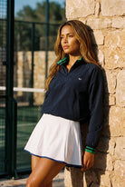 GRACE zip sweater & skirt set in Navy sweater white skirt – women's padel set by Six'o – lifestyle photo at the padel club