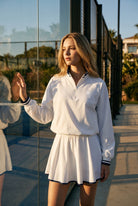 GRACE zip sweater & skirt set in White set – women's padel set by Six'o – lifestyle photo at the padel club