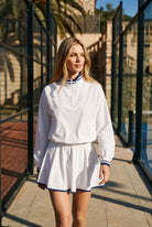 GRACE zip sweater & skirt set in White set – women's padel set by Six'o – lifestyle photo at the padel club