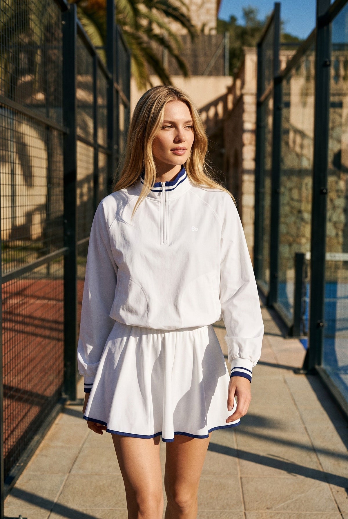 GRACE zip sweater & skirt set in White set – women's padel set by Six'o – lifestyle photo at the padel club