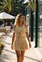 LILA cold-shoulder top & tiered skirt set in Almond yellow – women's padel set by Six'o – lifestyle photo at the padel club