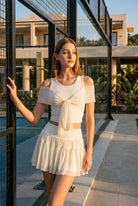 LILA cold-shoulder top & tiered skirt set in White – women's padel set by Six'o – lifestyle photo at the padel club