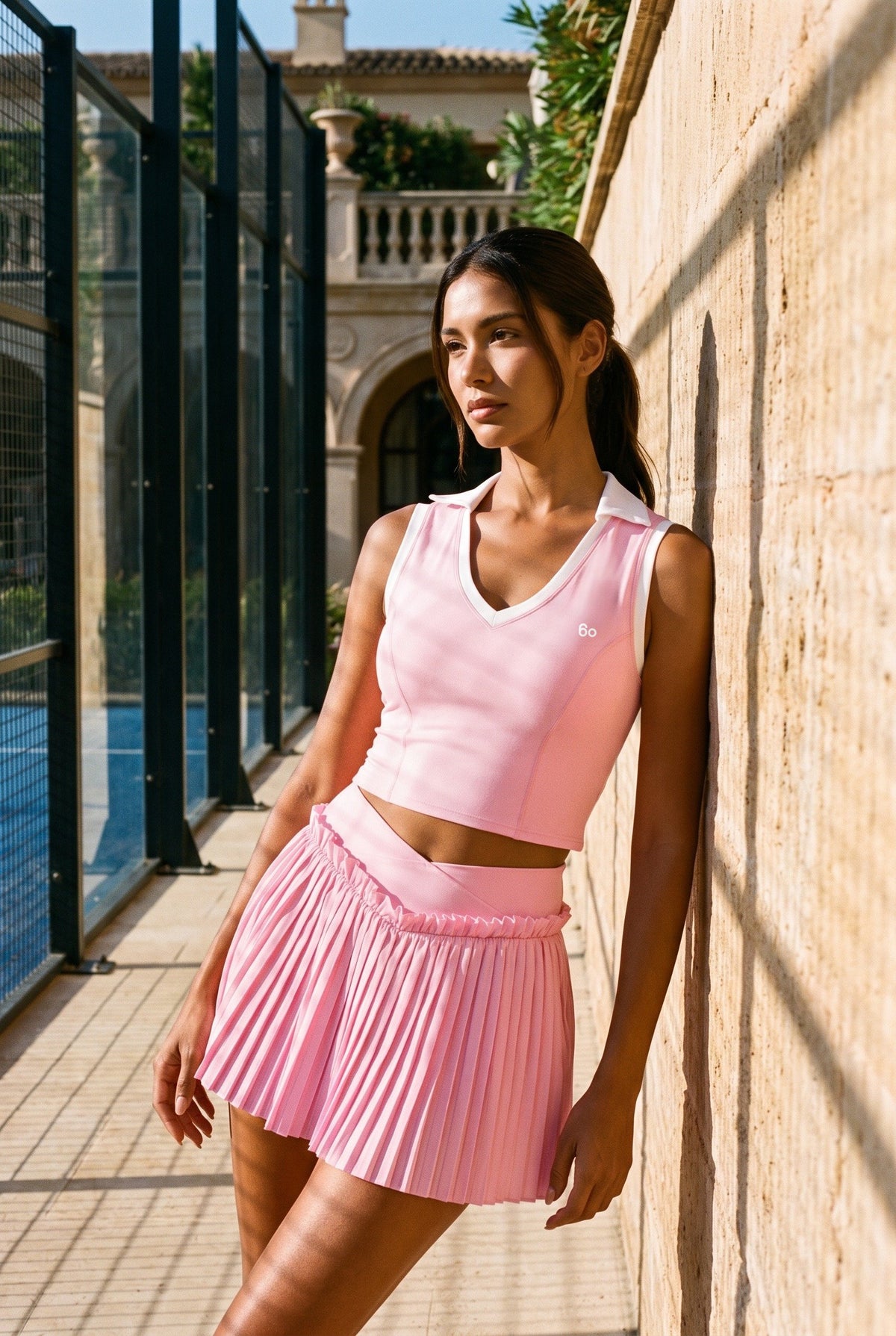 LUNA v-neck top & pleated skirt set in Pink – women's padel set by Six'o – lifestyle photo at the padel club