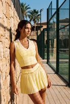 LUNA v-neck top & pleated skirt set in Yellow – women's padel set by Six'o – lifestyle photo at the padel club