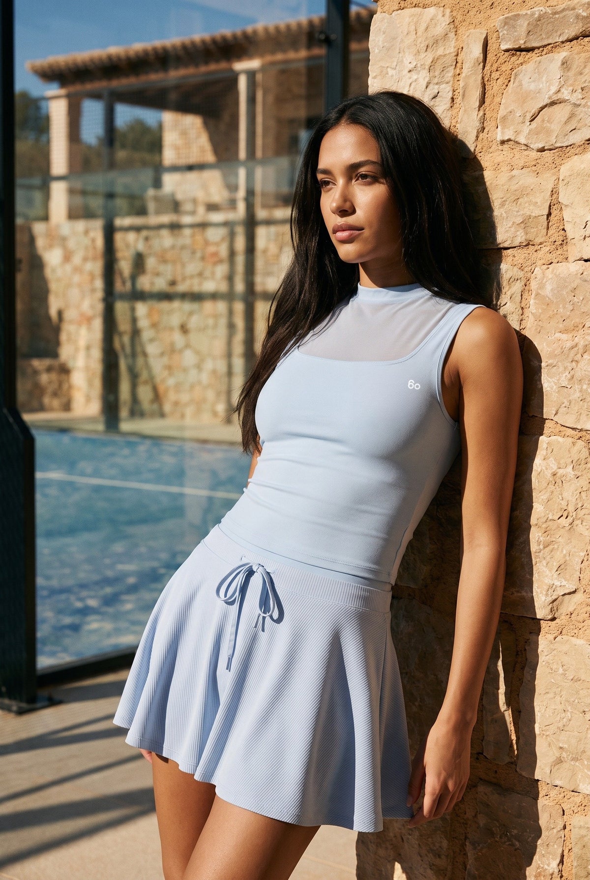 MAYA mesh tank & pleated skirt set in Blue – women's padel set by Six'o – lifestyle photo at the padel club