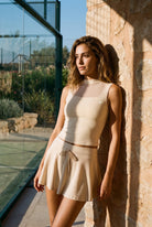 MAYA mesh tank & pleated skirt set in Milk apricot – women's padel set by Six'o – lifestyle photo at the padel club