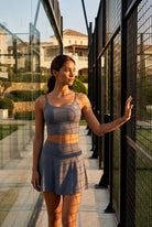 MILA cami bra & flare skirt set in Grey – women's padel set by Six'o – lifestyle photo at the padel club