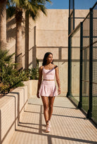 MILA cami bra & flare skirt set in Pink – women's padel set by Six'o – lifestyle photo at the padel club