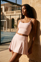MILA cami bra & flare skirt set in Pink – women's padel set by Six'o – lifestyle photo at the padel club