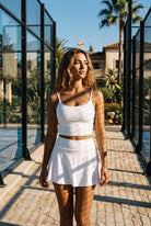 MILA cami bra & flare skirt set in White – women's padel set by Six'o – lifestyle photo at the padel club