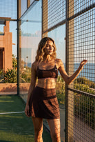 OLIVIA strap bra & skirt set in Dark brown – women's padel set by Six'o – lifestyle photo at the padel club