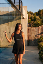RUBY piped tank pleated dress in Black – women's padel dress by Six'o – lifestyle photo at the padel club
