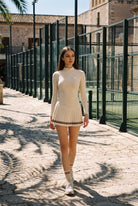 STELLA long sleeve & pleated skirt set in Beige – women's padel set by Six'o – lifestyle photo at the padel club
