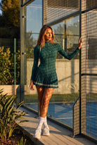 STELLA long sleeve & pleated skirt set in Dark green – women's padel set by Six'o – lifestyle photo at the padel club