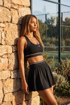 TESSA striped tank & pleated skirt set in Black – women's padel set by Six'o – lifestyle photo at the padel club