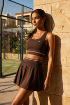 TESSA striped tank & pleated skirt set in Espresso brown – women's padel set by Six'o – lifestyle photo at the padel club