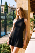 ZOE high neck padel dress in Black – women's padel dress by Six'o – lifestyle photo at the padel club