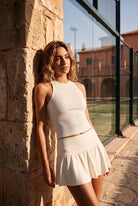 ZOE high neck padel dress in Heron white – women's padel dress by Six'o – lifestyle photo at the padel club