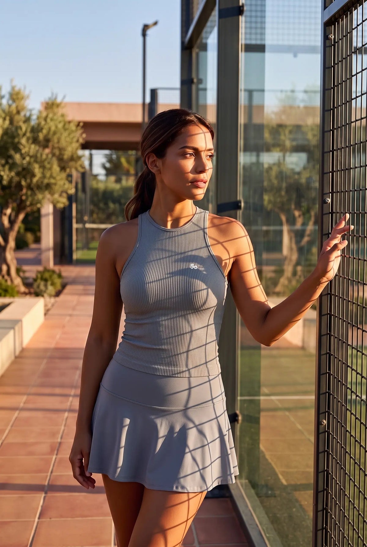 ZOE high neck padel dress in Pewter grey – women's padel dress by Six'o – lifestyle photo at the padel club