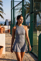ZOE high neck padel dress in Pewter grey – women's padel dress by Six'o – lifestyle photo at the padel club